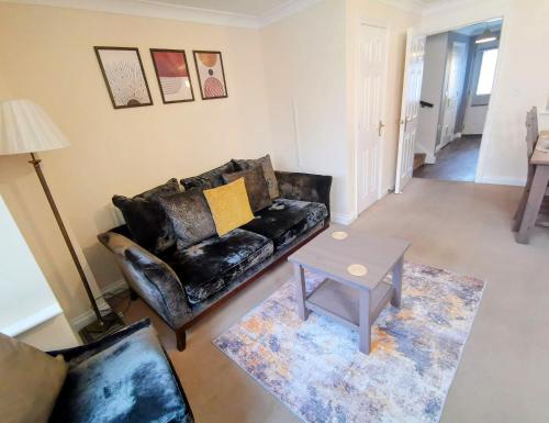 a living room with a leather couch and a table at No 23- Large Spacious 3 Bed Home - Parking & WiFi in Nantwich