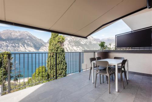 einen Balkon mit einem Tisch und Stühlen sowie Bergblick in der Unterkunft Apartment Bellavista in Nago-Torbole