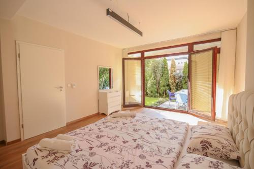 a bedroom with a bed and a large window at Green Oasis in the City Center in Pristina