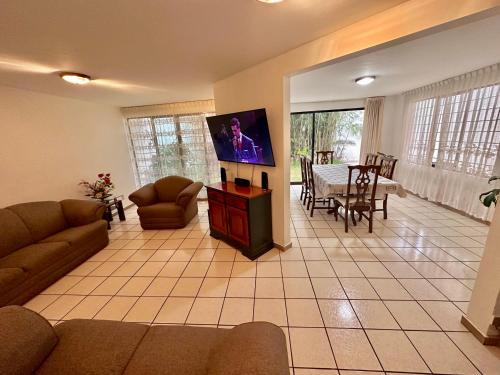 a living room with a flat screen tv and a table at Casa Garcia-5 habitaciones, Auditorio GNP Estadios CC Parque Puebla in San Felipe Hueyotlipan