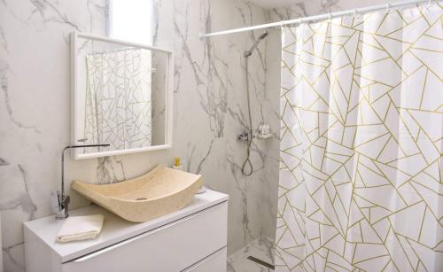 a bathroom with a shower with a sink and a mirror at UpForest Guesthouse in Călimăneşti