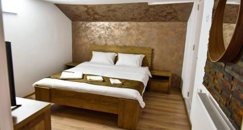 a bedroom with a bed with two towels on it at UpForest Guesthouse in Călimăneşti