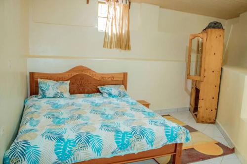 a bedroom with a bed with blue and white sheets at Kigali bright housse in Kigali