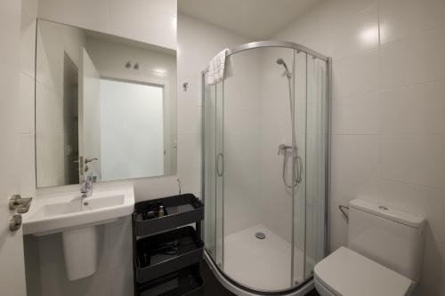 a bathroom with a shower and a toilet and a sink at Pensión T5 Donostia Suites in San Sebastián