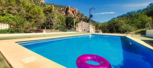 una piscina con un flotador rosa en el medio en Els Orgues de Benitandús, en Alcudia de Veo