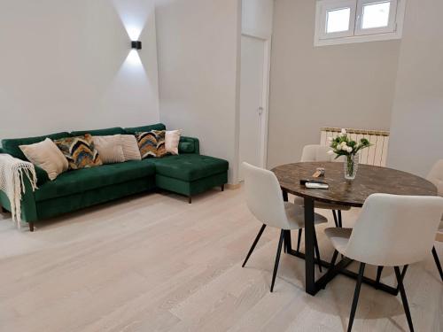 a living room with a green couch and a table at Casa nicola- apt in the heart of Rome in Rome