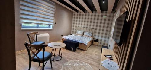 a small room with a bed and a table and chairs at Something Different in Nikšić