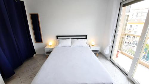 a white bed in a room with a window at Sunny Mercury - Room in Apartment in Cannes