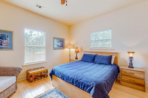 a bedroom with a blue bed and two windows at Up a Lazy River in Shoreline Park