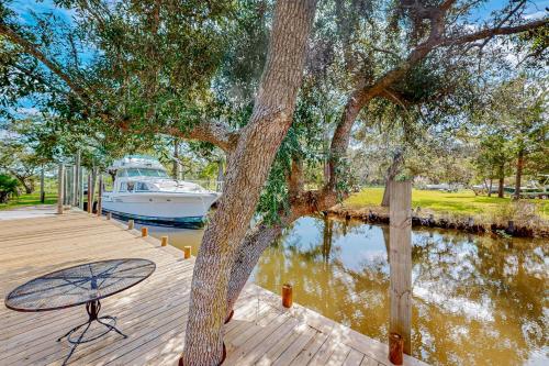 a boat is parked on a dock next to a tree at Up a Lazy River in Shoreline Park