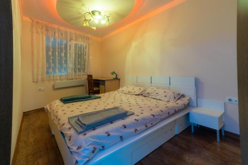 a bedroom with a bed with a white bedspread and a ceiling at Cozy Apart TOP Center AUBG Free Garage Park in Blagoevgrad