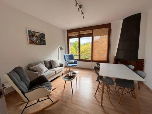 sala de estar con sofá, sillas y mesa en El Bressol de la Muntanya, en Ripoll
