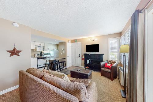 a living room with two couches and a kitchen at Condo 708 at North Creek Resort in Blue Mountains