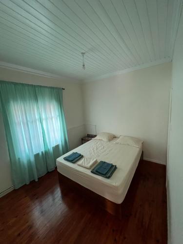 Cama blanca en habitación con suelo de madera en 90m2 2 Bedroom Apartment in Myrina Center - Port of Myrina en Mirina