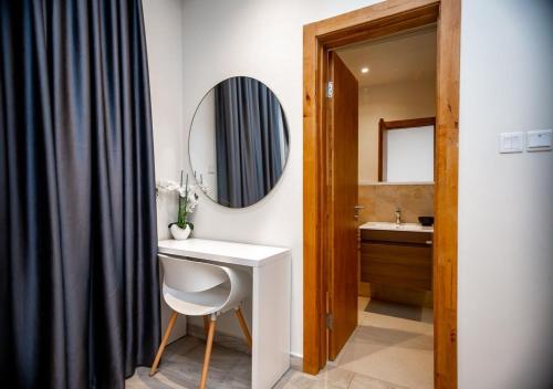 阿克拉的住宿－Manjaro Luxury Suites at Stella Place, East Legon，一间带水槽和镜子的浴室
