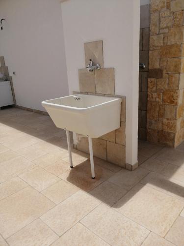 a white sink in a bathroom with a tile floor at Onde Salentine Deluxe in Casalabate