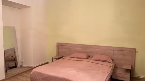 a bedroom with a large bed with pink sheets at Asatryan’s Guest House in Vagharshapat