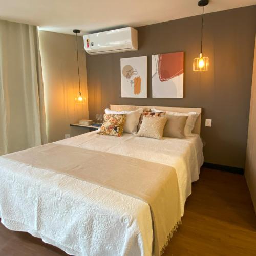 a bedroom with a large white bed with pillows at Rio Holiday Boutique Hotel in Niterói