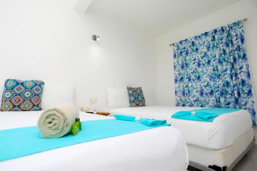 Habitación con 2 camas y sofá en Hotel Maria de Lourdes, en Cancún