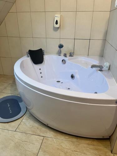 Zajazd Cicha Woda في Maniowy: حوض استحمام أبيض جالس في الحمام