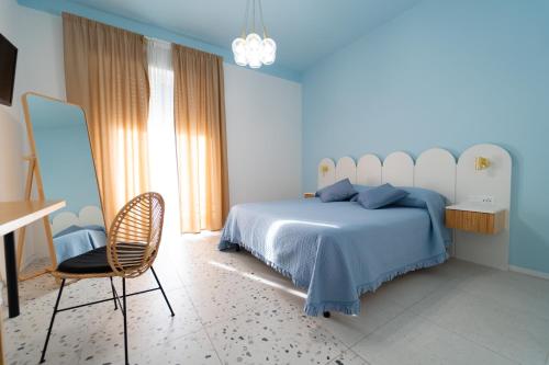 a bedroom with a bed and a chair and a desk at Il Grande Blu in Terracina