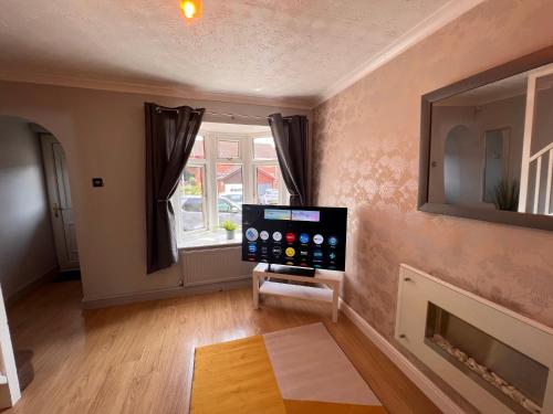 a living room with a tv and a fireplace at CONTRACTORS OR FAMILY HOUSE - M1 Nottingham - IKEA RETAIL PARK - CATKIN DRIVE - 2 Bed Home with Driveway, private garden, sleeps 4 - TV'S in all rooms in Giltbrook