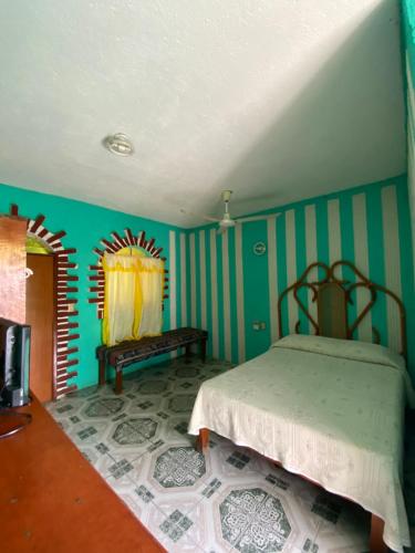 - une chambre avec un lit dans une pièce aux murs bleus dans l'établissement Hotel Villa Luz, à Puerto Escondido