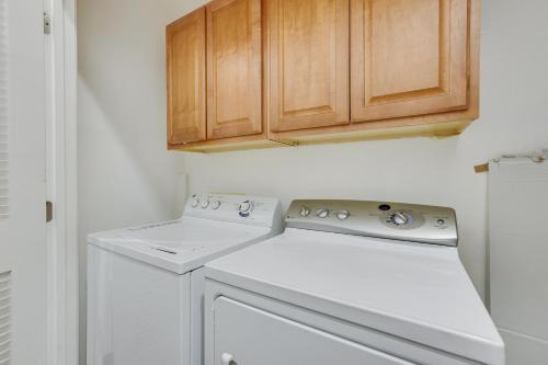 a kitchen with a washer and dryer and wooden cabinets at Rooftop Patio, Skyline Views Phoenix Townhome! in Phoenix