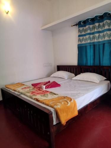 a large bed in a bedroom with a blue curtain at Marari diya homestay in Mararikulam