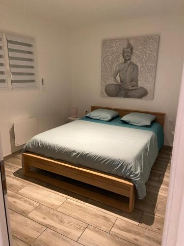 um quarto com uma cama com uma fotografia na parede em Maison indépendante 