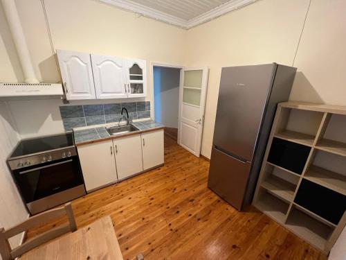 eine Küche mit weißen Schränken und einem Kühlschrank aus Edelstahl in der Unterkunft 45m2 1 Bedroom Apartment in Myrina Center - Port of Myrina in Mirina