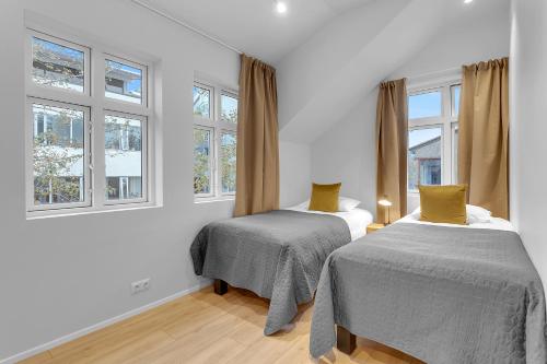 2 Betten in einem Zimmer mit 2 Fenstern in der Unterkunft Capital Luxury Apartments in Reykjavík