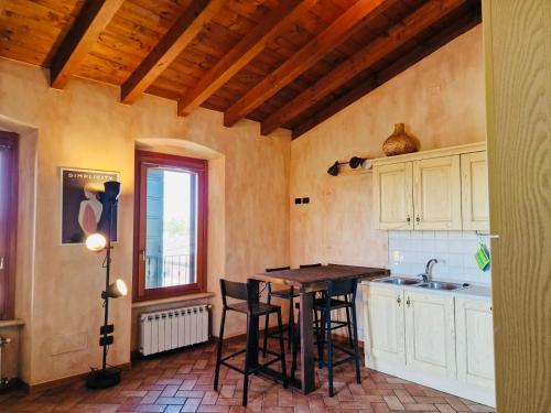 eine Küche mit einem Tisch, Stühlen und einem Waschbecken in der Unterkunft Vittoria alla Torre in Pozzolengo