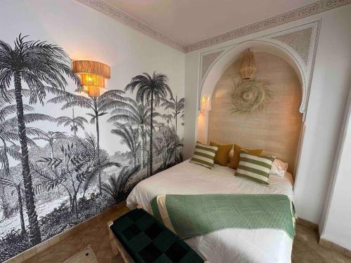 a bedroom with a mural of palm trees on the wall at Riad ABADA Medina Marrakech (Sidi Mimoun) in Marrakesh
