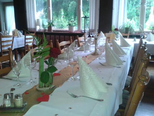 a long table with wine glasses and flowers on it at Hotel Restaurant Albans Sonne in Bad Rippoldsau