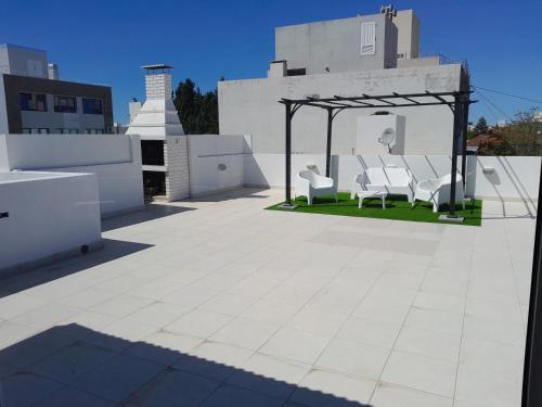 a patio with chairs and a gazebo on a roof at MAILAR d1 in Puerto Madryn