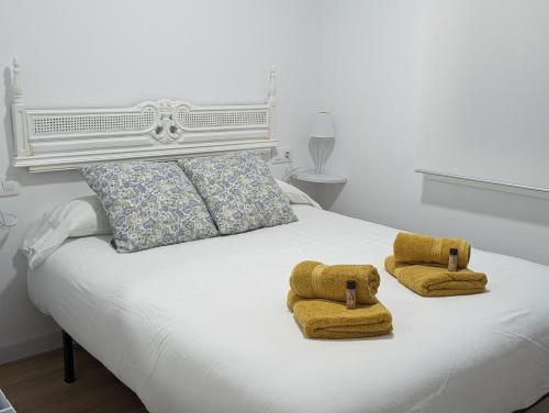 a white bed with two towels on top of it at Casa hierro in Vigo