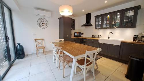 a kitchen with a table and chairs and a sink at Maison d'architecte centre Tours jardin, climatisation, parking 5 p in Tours