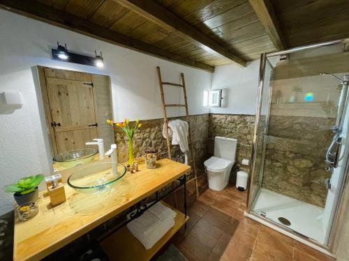 a bathroom with a sink and a shower at Tufa Guest House, Wellness & SPA - Villa Campus in Corredoura