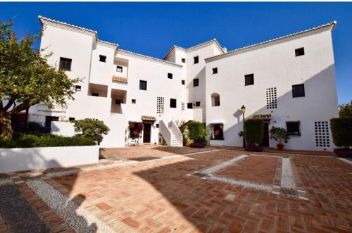ein großes weißes Gebäude mit einem gemauerten Innenhof in der Unterkunft Pueblo los Monteros in Marbella