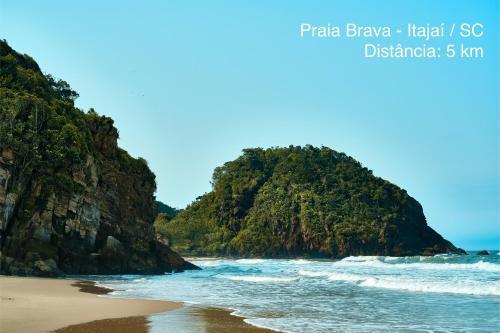 a view of a beach with a mountain in the background at Hotel Graju Itajaí in Itajaí