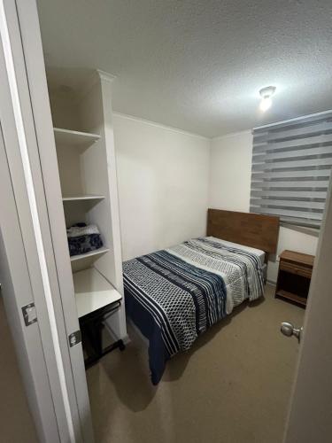 Dormitorio pequeño con cama y armario en Cómodo Dpto en Curicó en Curicó