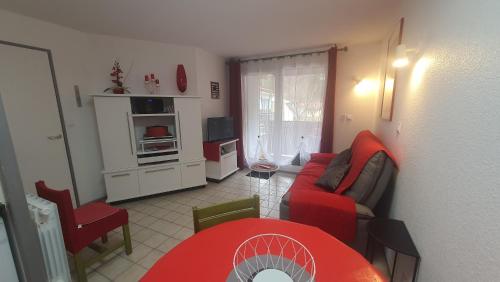 - un salon avec un canapé rouge et une table rouge dans l'établissement JOLI T2 DANS UN ECRIN DE VERDURE n 2, à Digne-Les-Bains