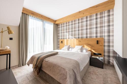 a bedroom with a bed and a large window at Rezydencja OWCA NA SZLAKU in Zakopane