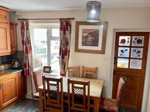 uma cozinha com mesa e cadeiras e uma janela em Pilgrims Rest with Annexe em Cheddar