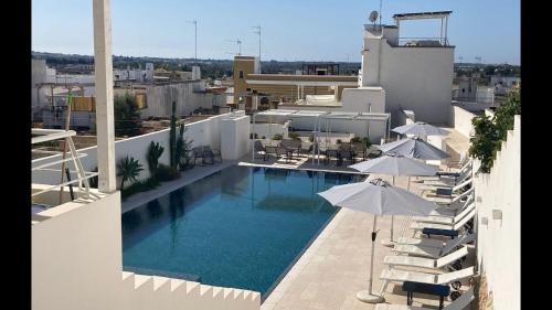 una piscina in cima a un edificio con ombrelloni di Azalea Suite Deluxe a Sannicola