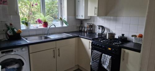 a kitchen with a sink and a stove top oven at Yvonnehut in Luton