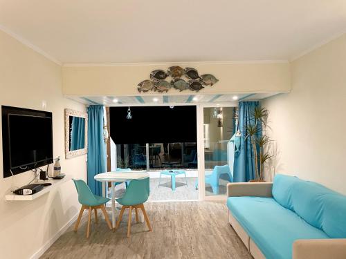 a living room with a blue couch and a table at O som das ondas - vista soberba de mar in Sesimbra