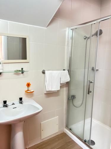 a bathroom with a sink and a shower at Central Guest House in Figueira da Foz