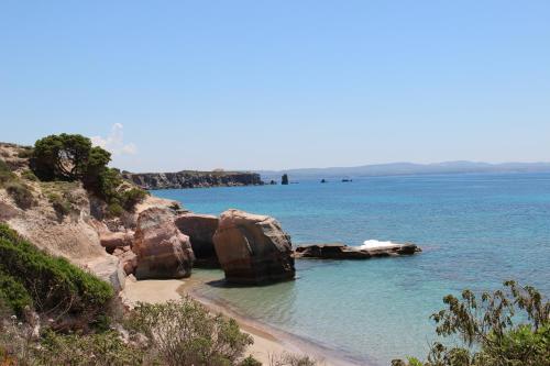 a beach with rocks and the ocean in the background at Casa Pein in Carloforte